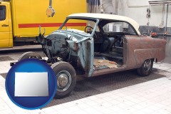a vintage automobile in an auto body shop - with CO icon