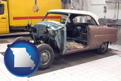 a vintage automobile in an auto body shop - with MO icon