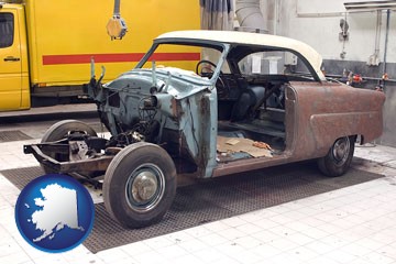 a vintage automobile in an auto body shop - with Alaska icon