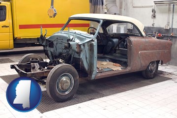 a vintage automobile in an auto body shop - with Mississippi icon