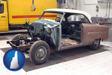 a vintage automobile in an auto body shop - with New Hampshire icon