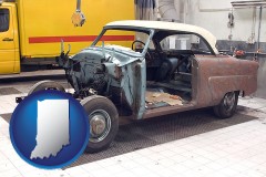 a vintage automobile in an auto body shop - with IN icon