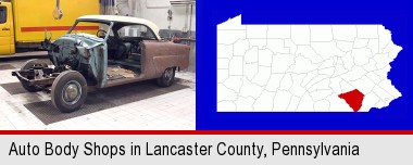 a vintage automobile in an auto body shop; Lancaster County highlighted in red on a map